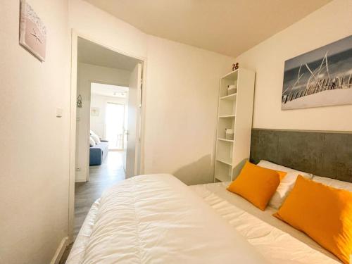 - une chambre avec un lit et deux oreillers orange dans l'établissement Charmant T2 avec terrasse vue mer, à Bandol