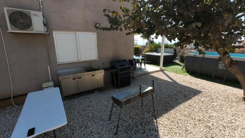 a patio with a table and a sink and a building at גבוה בגלבוע in Gan Ner