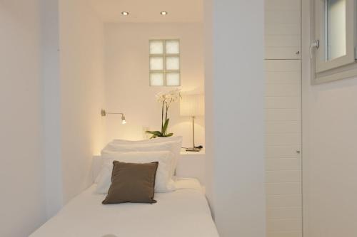 a white room with a bed with a pillow at Romantica Suites in Naousa
