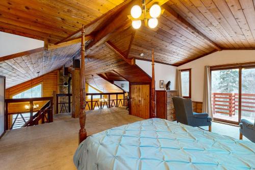 una camera da letto con un letto in una stanza con soffitti in legno di Eagle River Retreat a Eagle River