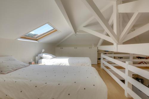 une chambre avec deux lits et une lucarne dans l'établissement Erlauntza, à Biarritz