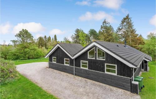 a black house with a gravel driveway at Holiday Home Marthasvej in Trend