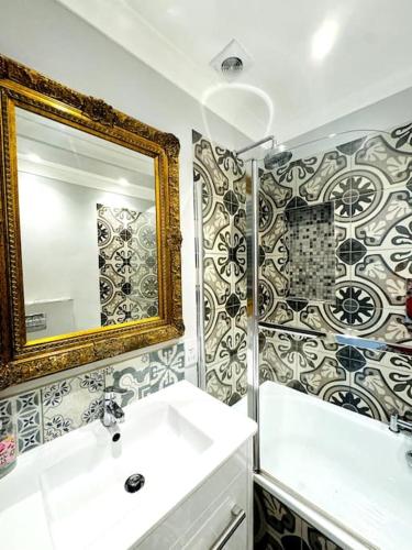 a bathroom with a sink and a mirror at Waves, Central Beach Town Apartment in Hastings