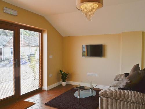 a living room with a couch and a tv at Oak Cottage in Winthorpe