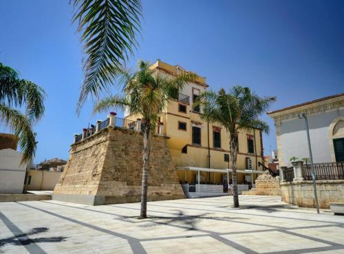 ein Gebäude mit Palmen davor in der Unterkunft Villa Sara - Villa con piscina in Marina di Ragusa