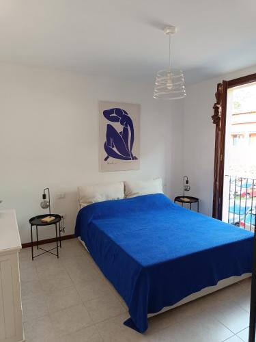 a bedroom with a blue bed and a window at Cosy apartment Aga in Collodi