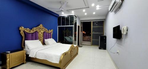 a bedroom with a bed and a blue wall at Citi Hotel Apartments in Jhelum