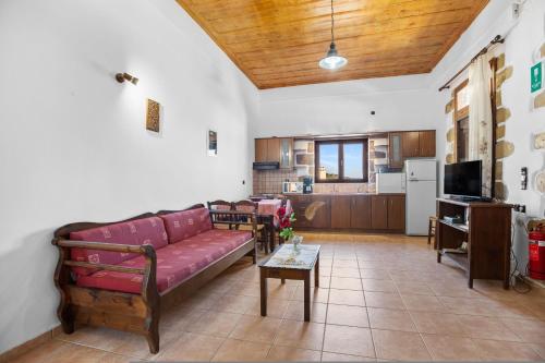 a living room with a red couch and a kitchen at Countryside Apartment 2 with Shared Swimming Pool in Chania Town