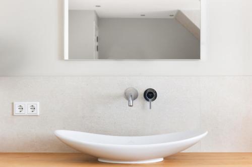 a bathroom with a white sink and a mirror at Zeayou Zeeland - Studio's Zuidstraat 1 in Domburg