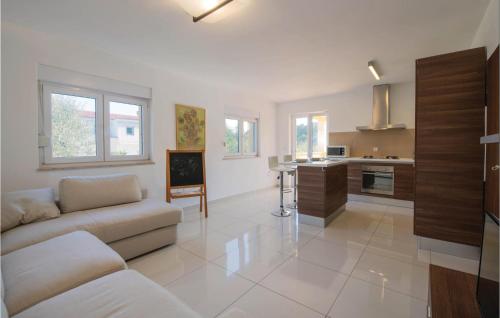 un salon avec un canapé et une cuisine dans l'établissement Two-Bedroom Holiday Home In Liznjan, à Ližnjan