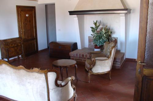 a living room with two chairs and a table at Il Canto del Sole in Monteroni dʼArbia