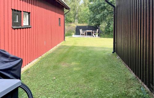 a yard with a red building and a picnic table at Klitterbyn 16 in Ängelholm