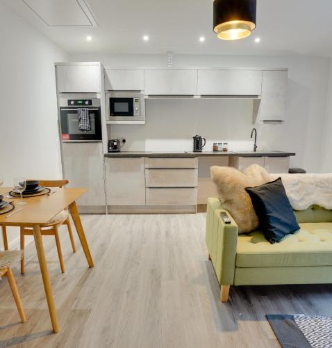 a living room with a couch and a table and a kitchen at No 3 at The Rocketroom Apartments in Berwick-Upon-Tweed