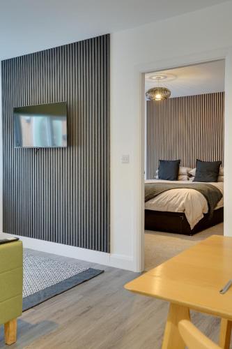 a bedroom with a bed and a tv on a wall at No 3 at The Rocketroom Apartments in Berwick-Upon-Tweed