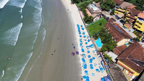 an overhead view of a beach with umbrellas and the ocean at Kaliman Pousada in Ubatuba