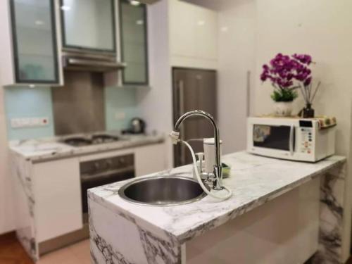 une cuisine avec un évier et un micro-ondes dans l'établissement WHITE HOUSE STRAITS QUAY MARINA LUXURY STAY GURNEY, à Tanjong Tokong
