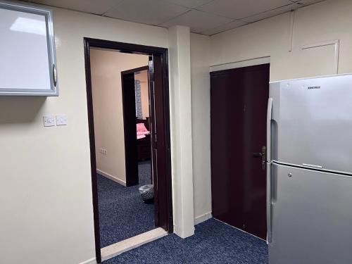 an office room with a refrigerator and a hallway at Queen Cleopatra suite in Ajman 