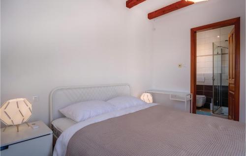 a white bedroom with a bed and a mirror at Pet Friendly Home In Sveti Jakov in Sveti Jakov
