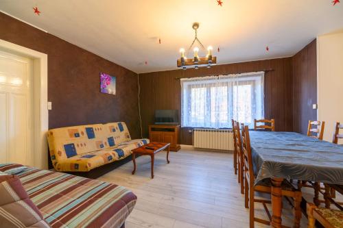 - un salon avec une table à manger et un canapé dans l'établissement Charmante Maison - Vosges, à Saulxures-sur-Moselotte