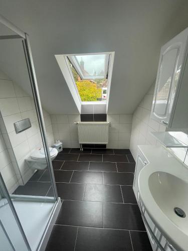 a bathroom with a toilet and a sink and a window at Ferienwohnung Ludwig mit Balkon in Karlstadt