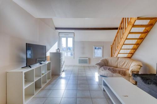 a living room with a couch and a tv at Studio grande cuisine in Étampes