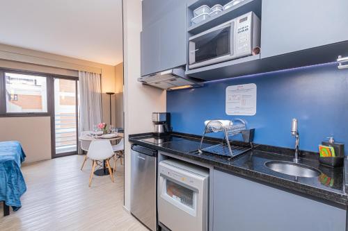 a kitchen with a sink and a microwave at APS - Alpha Stay By Anora Spaces in Barueri