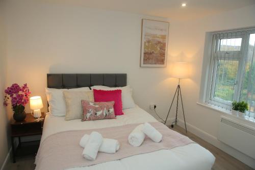 a bedroom with a large white bed with two pillows at Luxury Private Ensuite and Kitchenette Room Near Luton Airport 4 Min Drive in Luton