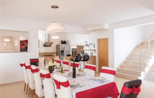 a dining room with a table with red and white chairs at Nice Home In Prizba With Sauna in Prizba
