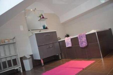 Una cocina con toallas rosas colgadas en un tendedero. en Hébergement Plage du Débarquement, en Foucarville