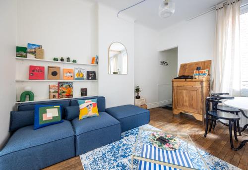 un salon avec un canapé bleu et une table dans l'établissement Appart 2 chambres I charmant & cosy I hyper-centre, à Reims