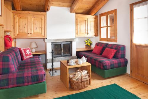 a living room with two couches and a fireplace at Albergo Diffuso Sauris in Sauris Di Sopra in Sauris