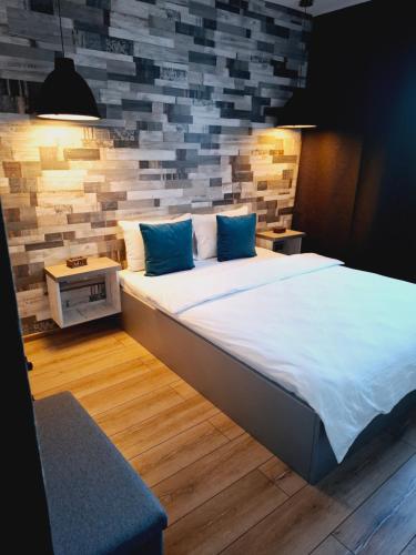 a large bed with blue pillows in a room at New Grey Apartament in Reghin