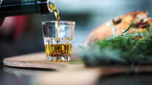 a drink being poured into a glass next to a pizza at Gut Hügle Erlebnishof in Ravensburg