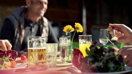 a group of people sitting at a table with food and drinks at Gut Hügle Erlebnishof in Ravensburg