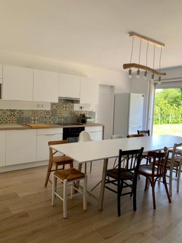 une cuisine et une salle à manger avec une table et des chaises dans l'établissement Villa Rose des Sables, à Andernos-les-Bains