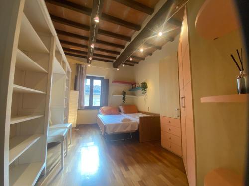 a bedroom with a bed and a room with shelves at APPARTAMENTO SULLA SALA in Pistoia