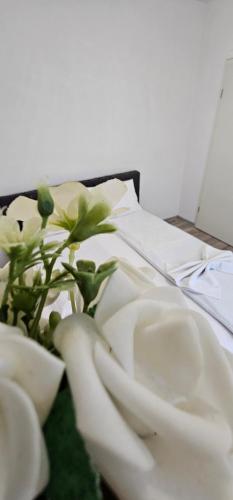 a table topped with white towels and a plant at Apartman Mima in Sanski most