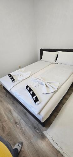 a bed with two remote controls on top of it at Apartman Mima in Sanski most