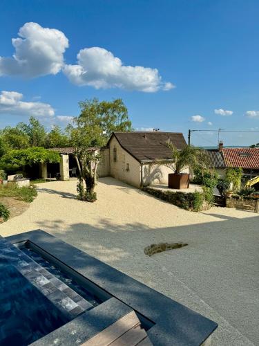 a yard with a house and a swimming pool at Le gîte 24 proche du Futuroscope - Jacuzzi compris in Beaumont