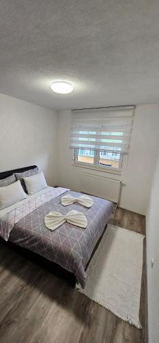 a bedroom with a bed with two towels on it at Apartman Mima in Sanski most