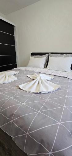 a bed with white sheets and pillows on it at Apartman Mima in Sanski most