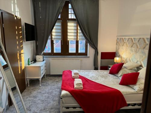 a bedroom with a bed with a red blanket at AmaMolto Train Station in Opole
