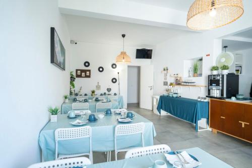 a dining room with a blue table and chairs at Villa Paraíso da Caparica in Charneca