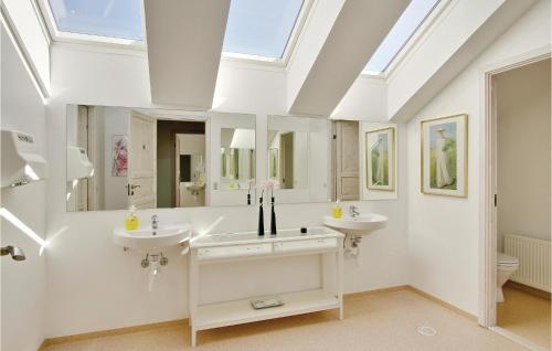 a bathroom with two sinks and a skylight at Bakkegården in Arup