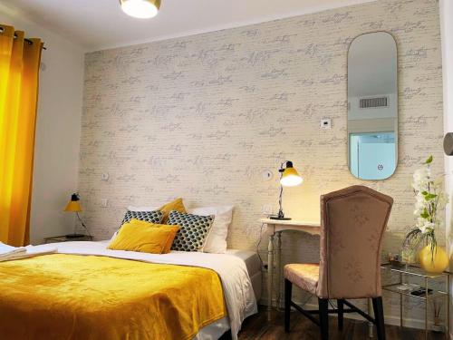 a bedroom with a bed and a desk and a chair at Le Jardin d'Eden by Leslodgespa in Blotzheim