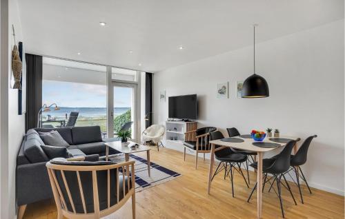a living room with a couch and a table and chairs at 2 Bedroom Lovely Home In Ebeltoft in Ebeltoft