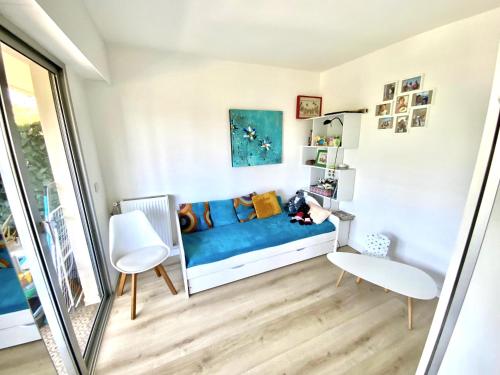 Cette petite chambre dispose d'un canapé bleu et d'une table. dans l'établissement Antibes t3, à Antibes