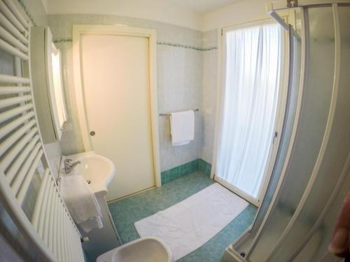 y baño con aseo, lavabo y ducha. en Residence Solemar - Agenzia Cocal, en Caorle