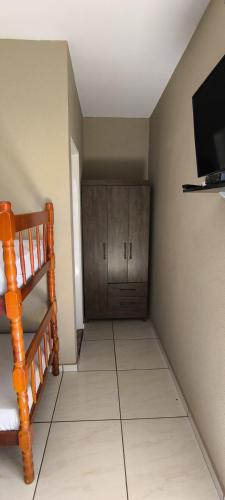 a living room with a tiled floor and a television at Hotel Modelo Rio Pardo in Ribas do Rio Pardo