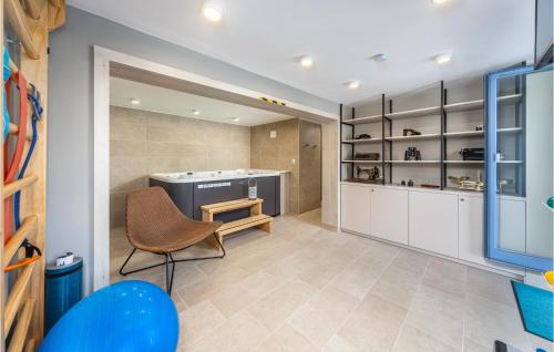 a kitchen with white cabinets and a chair in a room at Cozy Home In Omisalj With Sauna in Omišalj